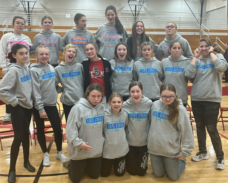 seveth grade lady braves team on basketball court wearing grey hoodies for picture